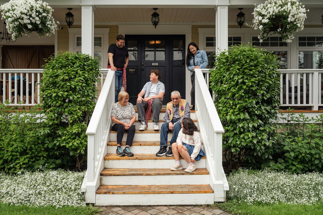Family sitting on the porch of a home